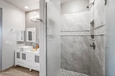 a bathroom with a double vanity sink a mirror and shower