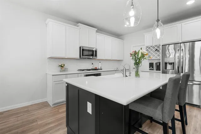 a kitchen with kitchen island a sink counter space and stainless steel appliances