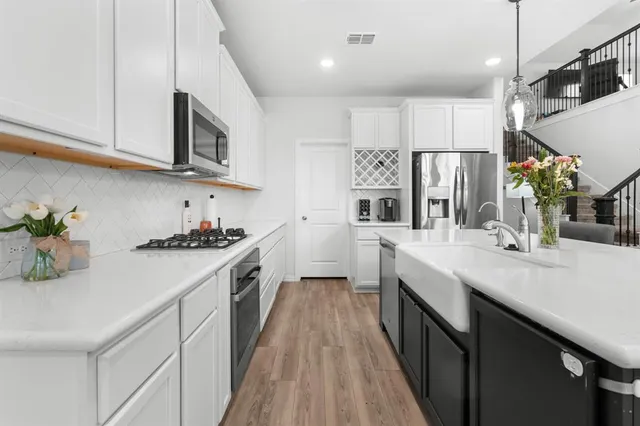 a kitchen with stainless steel appliances granite countertop a sink a stove and cabinets