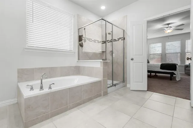 a spacious bathroom with a tub and a large mirror