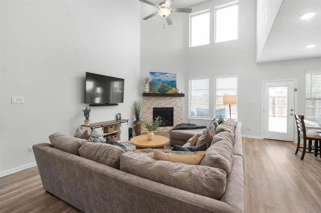 a living room with furniture a flat screen tv and a fireplace