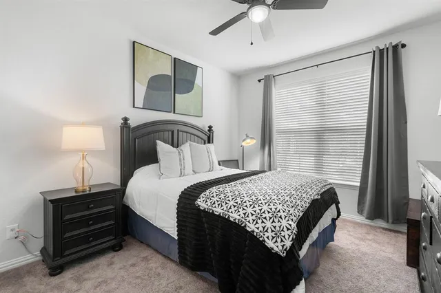 a bedroom with a bed lamp and a chandelier