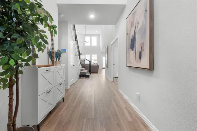 a view of a hallway with wooden floor and staircase