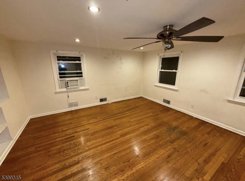 610 Lindegar Street Linden, NJ 07036 - Photo 3 of 8 a view of empty room with wooden floor and fan