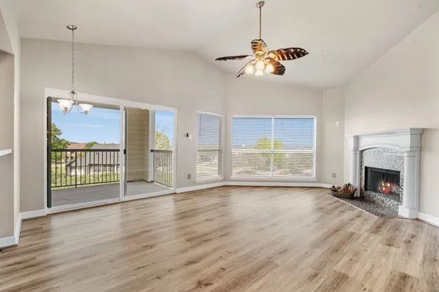 a view of an empty room with a window and fireplace