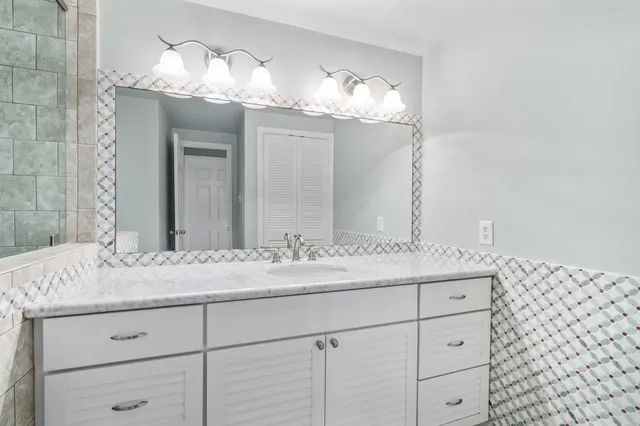 a bathroom with a sink vanity and a mirror