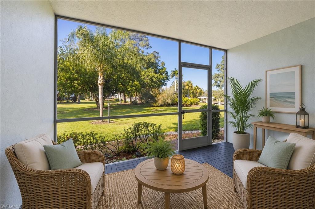 5737 Whitaker Road, Unit C101 Naples, FL 34112 - Photo 2 of 28 a living room with furniture and a floor to ceiling window