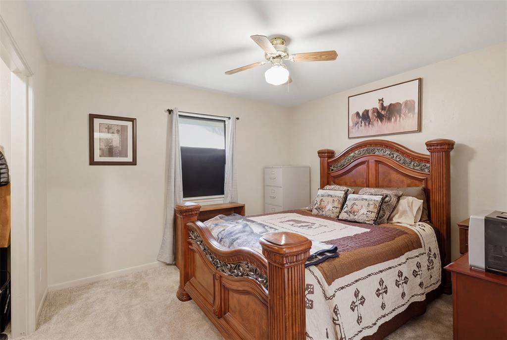 1644 County Road 195 Dublin, TX 76446 - Photo 18 of 34 a bedroom with a bed and a chandelier