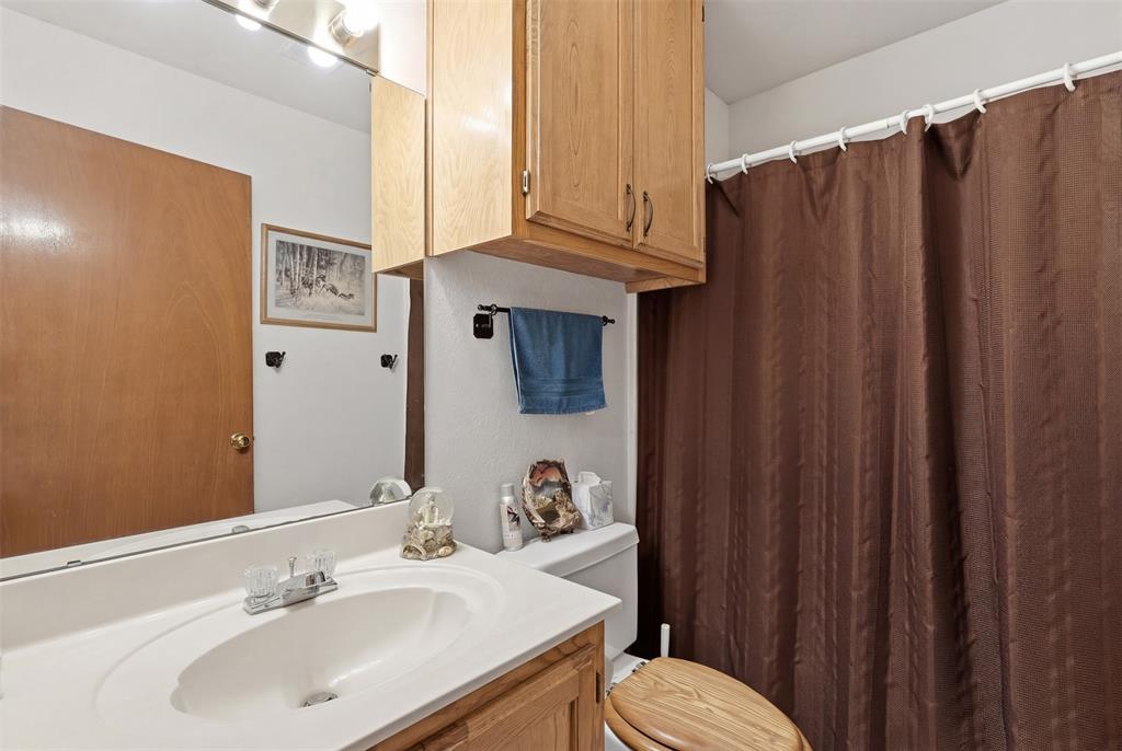 1644 County Road 195 Dublin, TX 76446 - Photo 19 of 34 a bathroom with a sink a toilet and shower curtain