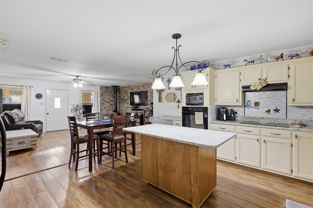 1644 County Road 195 Dublin, TX 76446 - Photo 9 of 34 a large kitchen with cabinets chairs and wooden floor
