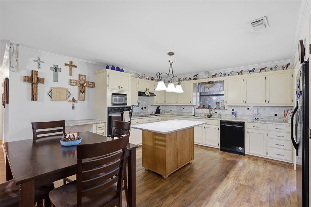1644 County Road 195 Dublin, TX 76446 - Photo 10 of 34 a kitchen with a refrigerator a stove and wooden floor