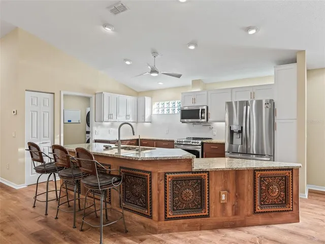 a kitchen with granite countertop a sink and a wooden floor