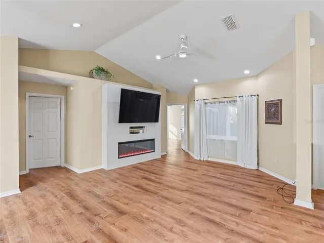 a view of a livingroom with wooden floor and a ceiling fan