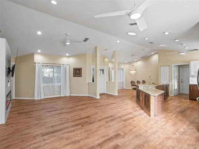 a view of an empty room with a window and a kitchen