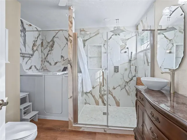 a bathroom with a sink a toilet and shower