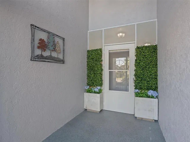 a view of a house with a yard and potted plants