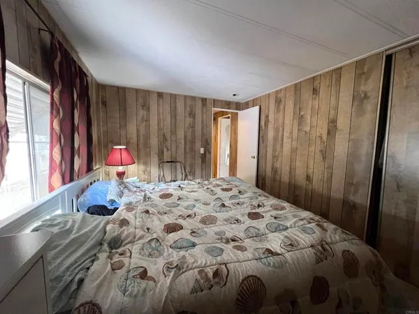 a bedroom with a bed and a window