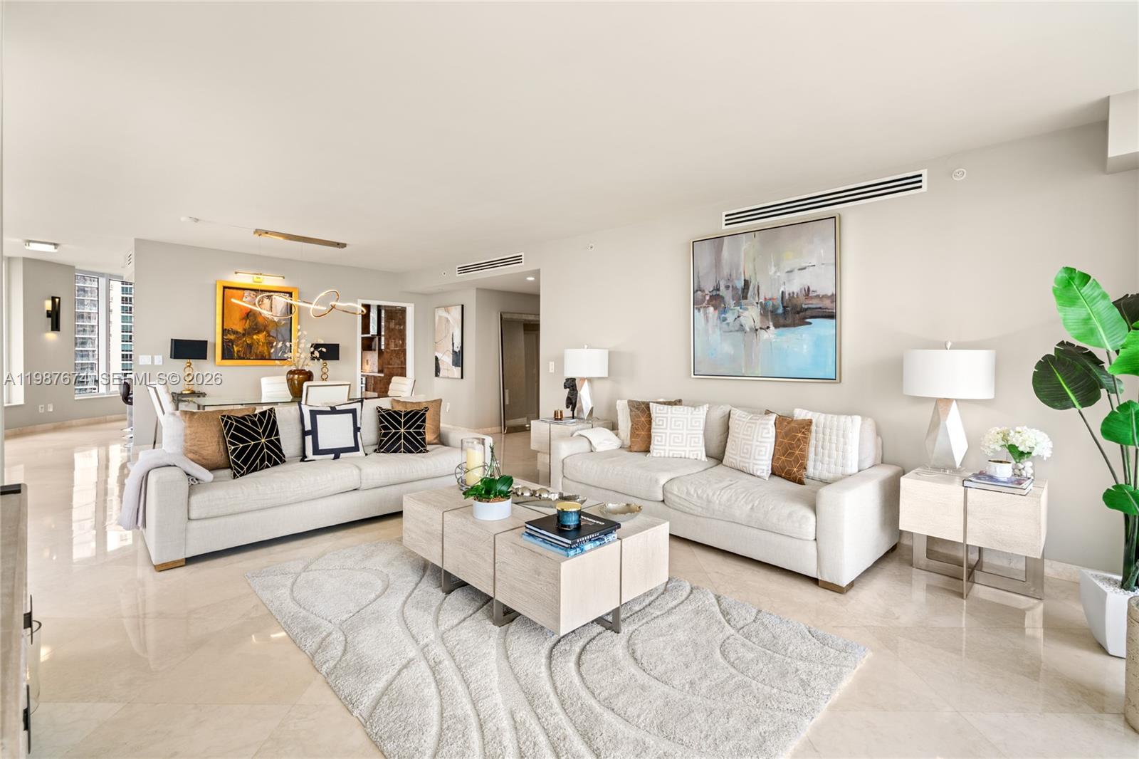 901 Brickell Key Boulevard, Unit 2804 Miami, FL 33131 - Photo 12 of 91 a living room with furniture white walls and a dining table with wooden floor