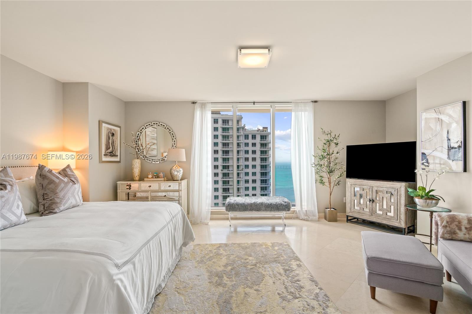 901 Brickell Key Boulevard, Unit 2804 Miami, FL 33131 - Photo 14 of 91 a bedroom with a bed and a flat screen tv on the dresser