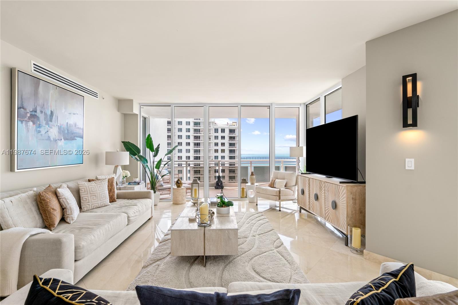 901 Brickell Key Boulevard, Unit 2804 Miami, FL 33131 - Photo 2 of 91 a living room with furniture and a flat screen tv