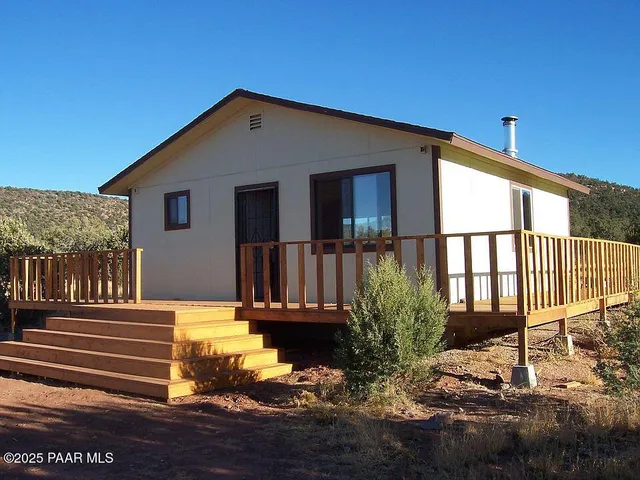 a view of a house with a small yard and wooden floor and fence