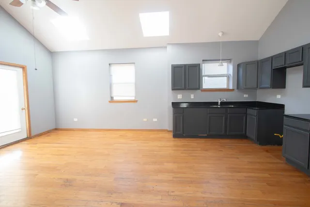 a view of a kitchen with cabinets and wooden floor