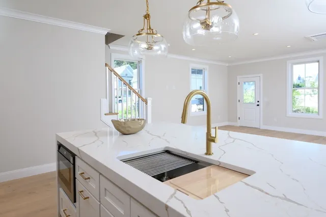 a kitchen with kitchen island granite countertop a sink stainless steel appliances and cabinets