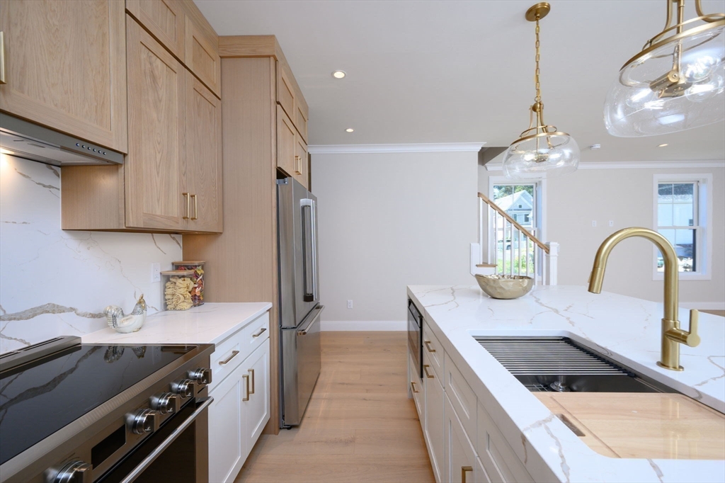 43 Chickatawbut Street, Unit 1 Boston, MA 02122 - Photo 9 of 42 a kitchen with kitchen island granite countertop a sink stainless steel appliances and cabinets