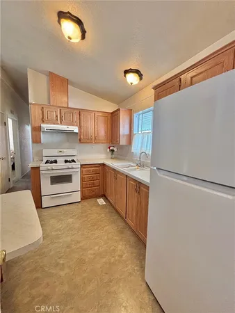a kitchen with granite countertop a refrigerator stove a sink and dishwasher