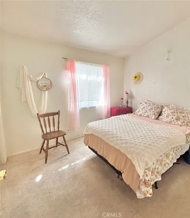 a bedroom with a bed chair and window