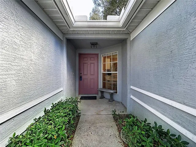a kitchen with stainless steel appliances kitchen island granite countertop a dining table chairs and a refrigerator