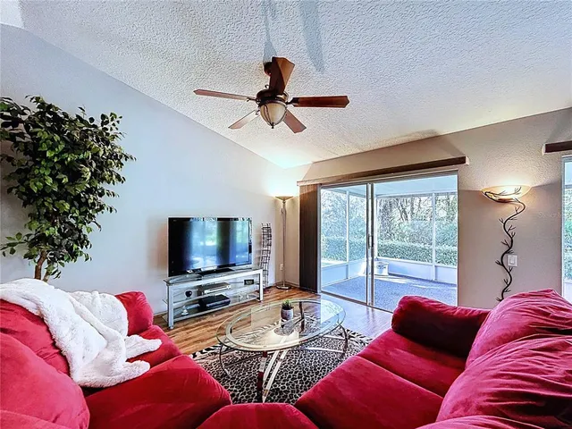 a living room with furniture a ceiling fan and a window