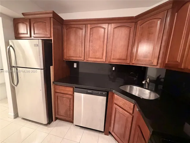 a kitchen with stainless steel appliances granite countertop a refrigerator a sink and dishwasher