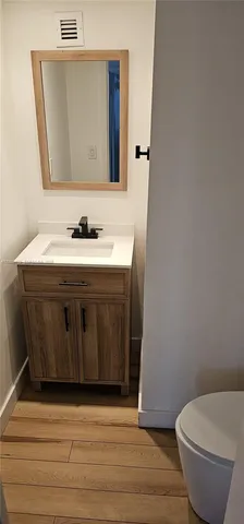 a bathroom with a toilet a sink and mirror