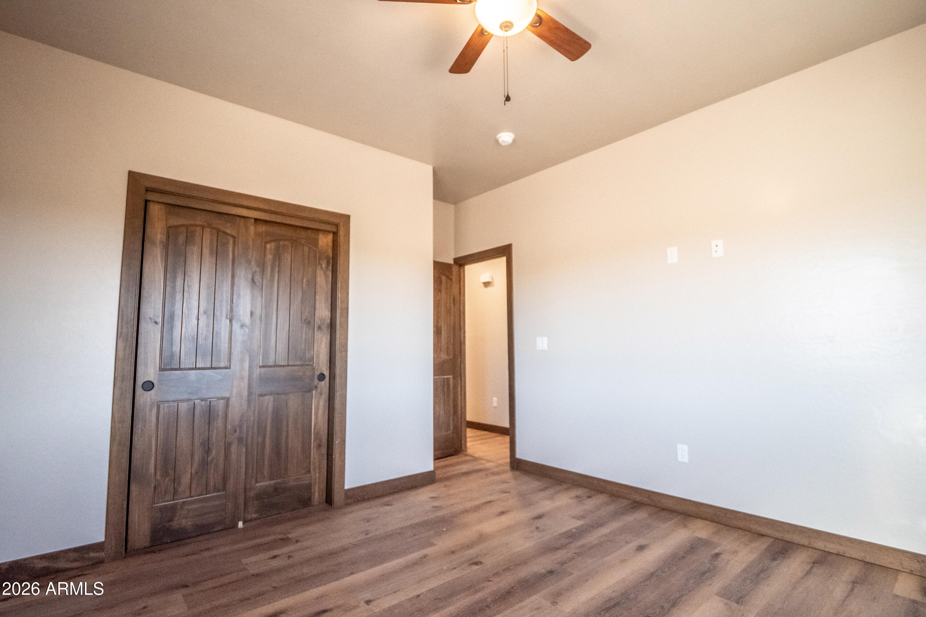 2021 East Rimstone Drive Show Low, AZ 85901 - Photo 35 of 38 an empty room with wooden floor fan and windows