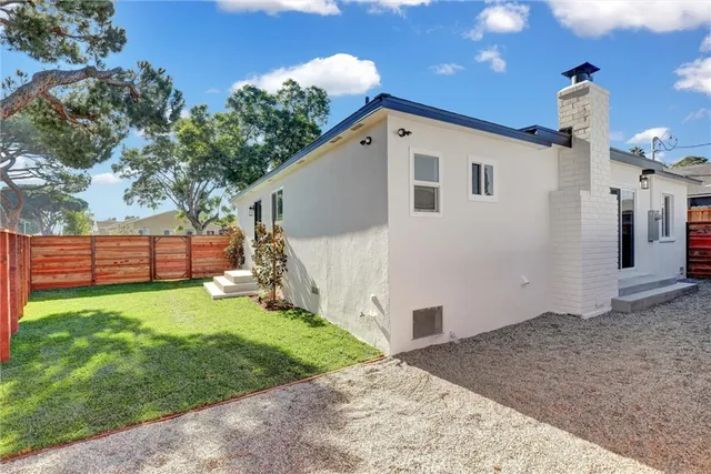 a view of a house with backyard and a tree