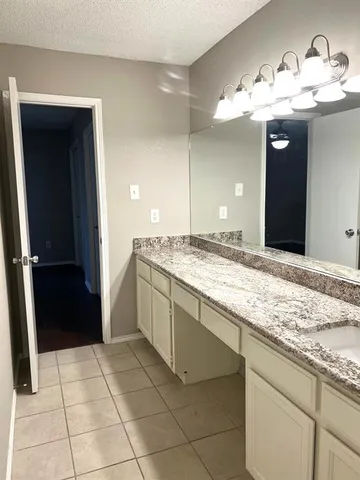 a bathroom with a granite countertop sink a mirror and a vanity