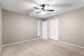 an empty room with ceiling fan and window