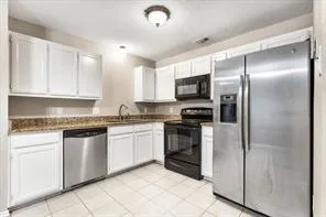 a kitchen with stainless steel appliances granite countertop a refrigerator and a stove