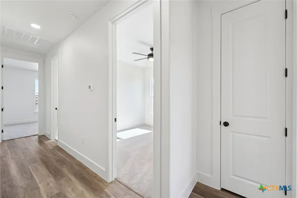 a view of a hallway with wooden floor