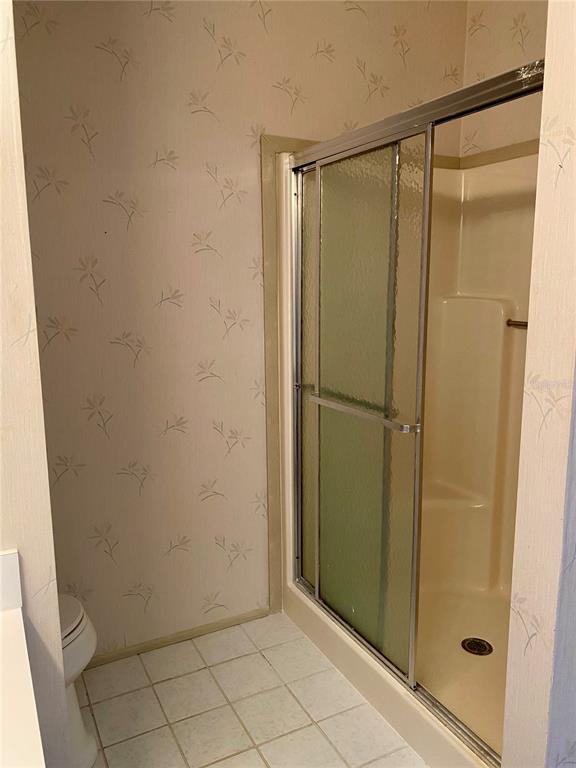 14517 Rialto Avenue Brooksville, FL 34613 - Photo 11 of 35 a bathroom with a glass shower door