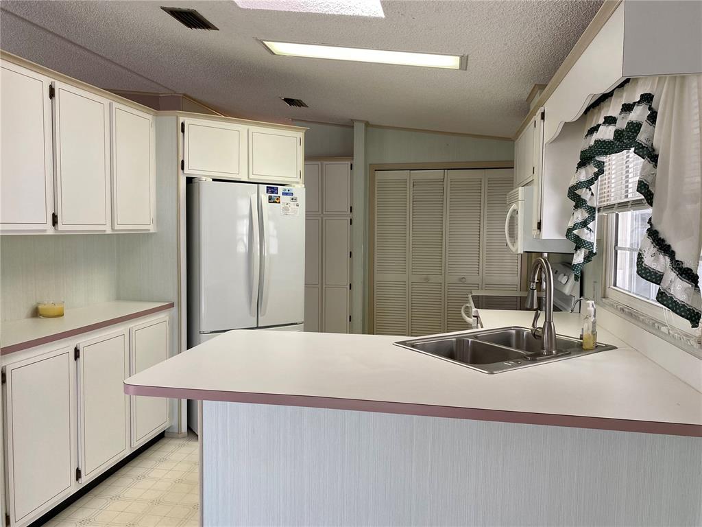 14517 Rialto Avenue Brooksville, FL 34613 - Photo 23 of 35 a kitchen with a refrigerator and countertop