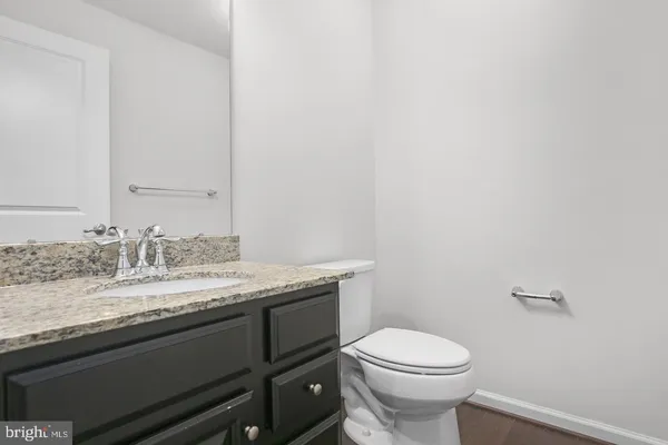 a bathroom with a granite countertop toilet sink and mirror