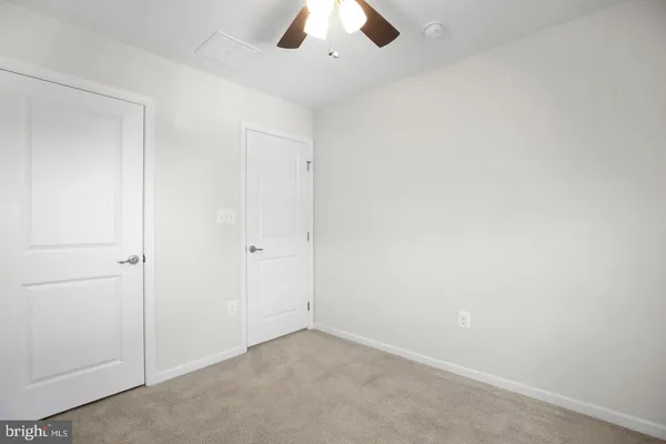 an empty room with a ceiling fan and a window