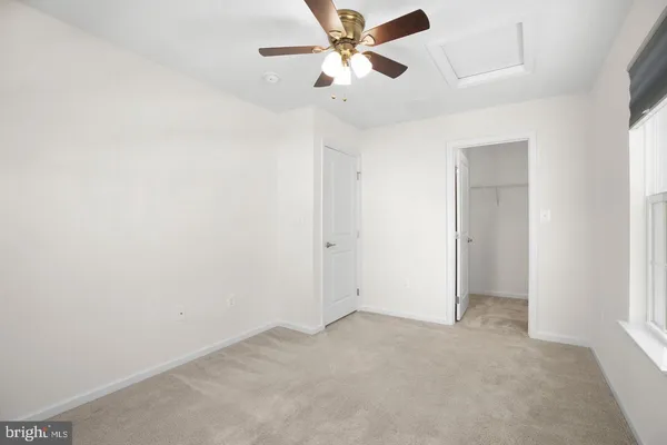 an empty room with a ceiling fan and a window