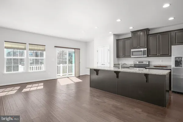 a kitchen with granite countertop wooden floors and white stainless steel appliances