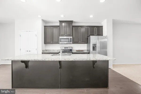 a kitchen with stainless steel appliances granite countertop a sink a refrigerator and a granite counter tops