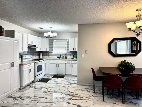 a kitchen with granite countertop a sink cabinets stainless steel appliances and a window