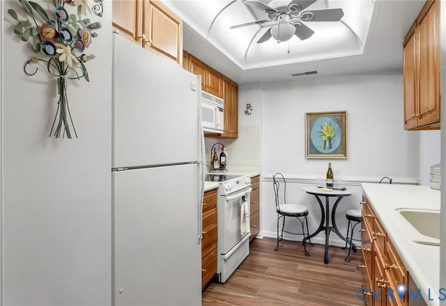 a kitchen with stainless steel appliances a refrigerator a sink a stove and white cabinets