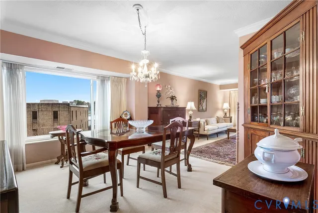 a dining room with furniture a chandelier and wooden floor